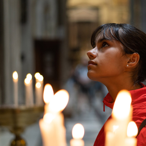 Une jeune fille priant dans une église